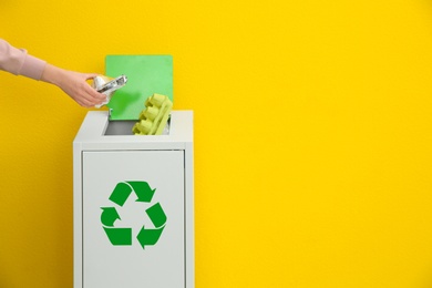 Photo of Woman putting used foil container into trash bin on color background, closeup with space for text. Recycling concept