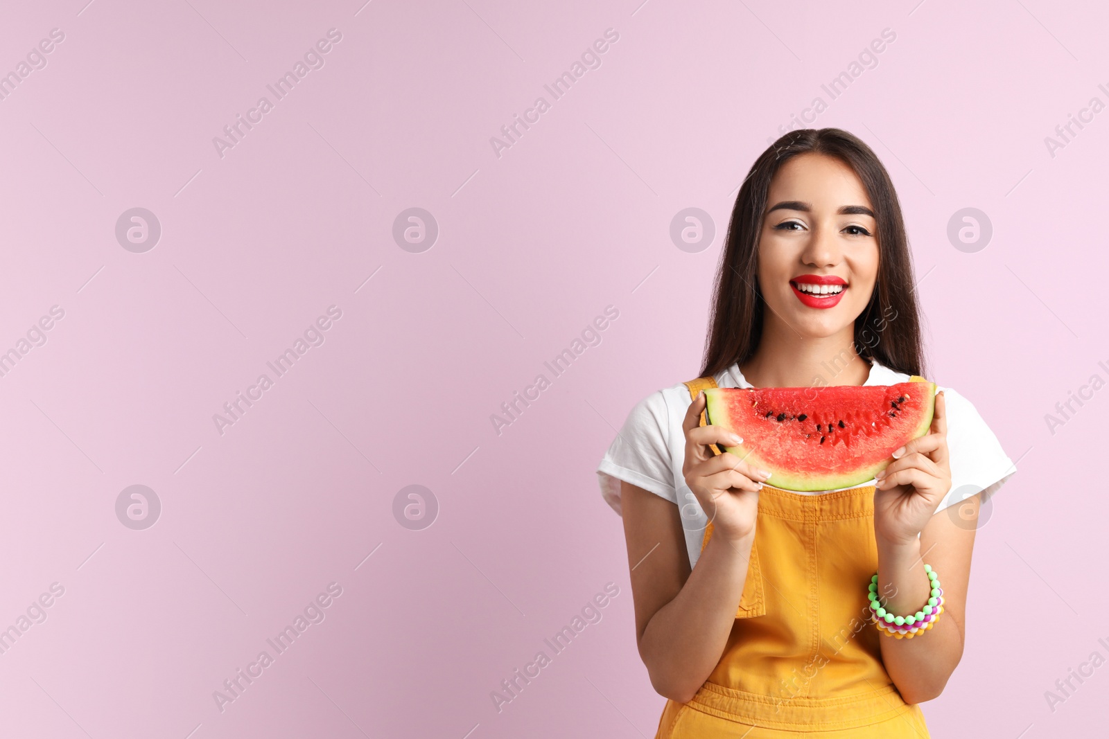 Photo of Beautiful young woman posing with watermelon on color background