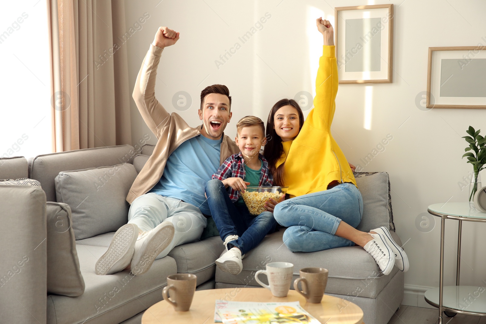 Photo of Happy family watching TV on sofa at home