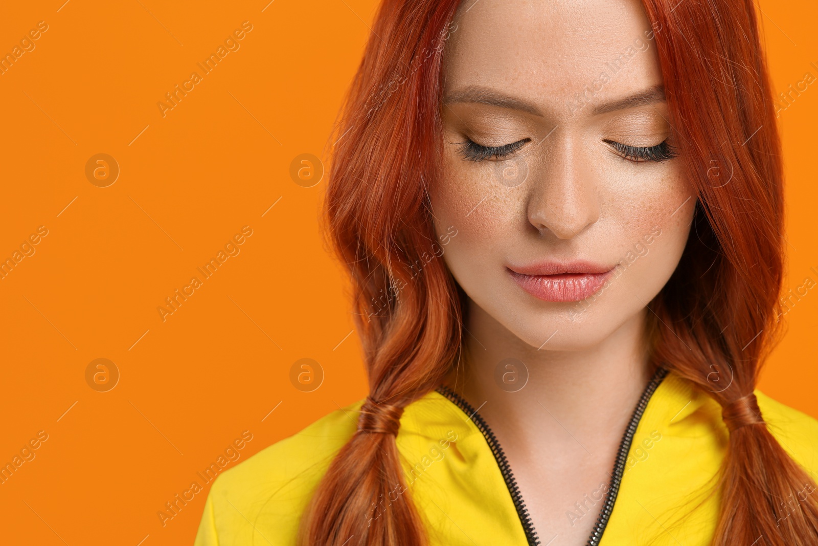 Photo of Beautiful woman with closed eyes on orange background. Space for text