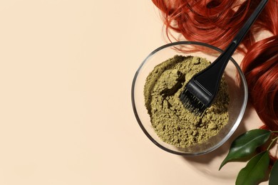 Photo of Bowl of henna powder, brush, green leaves and red strand on beige background, flat lay with space for text. Natural hair coloring