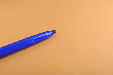 Photo of Blue marker on light brown background, space for text