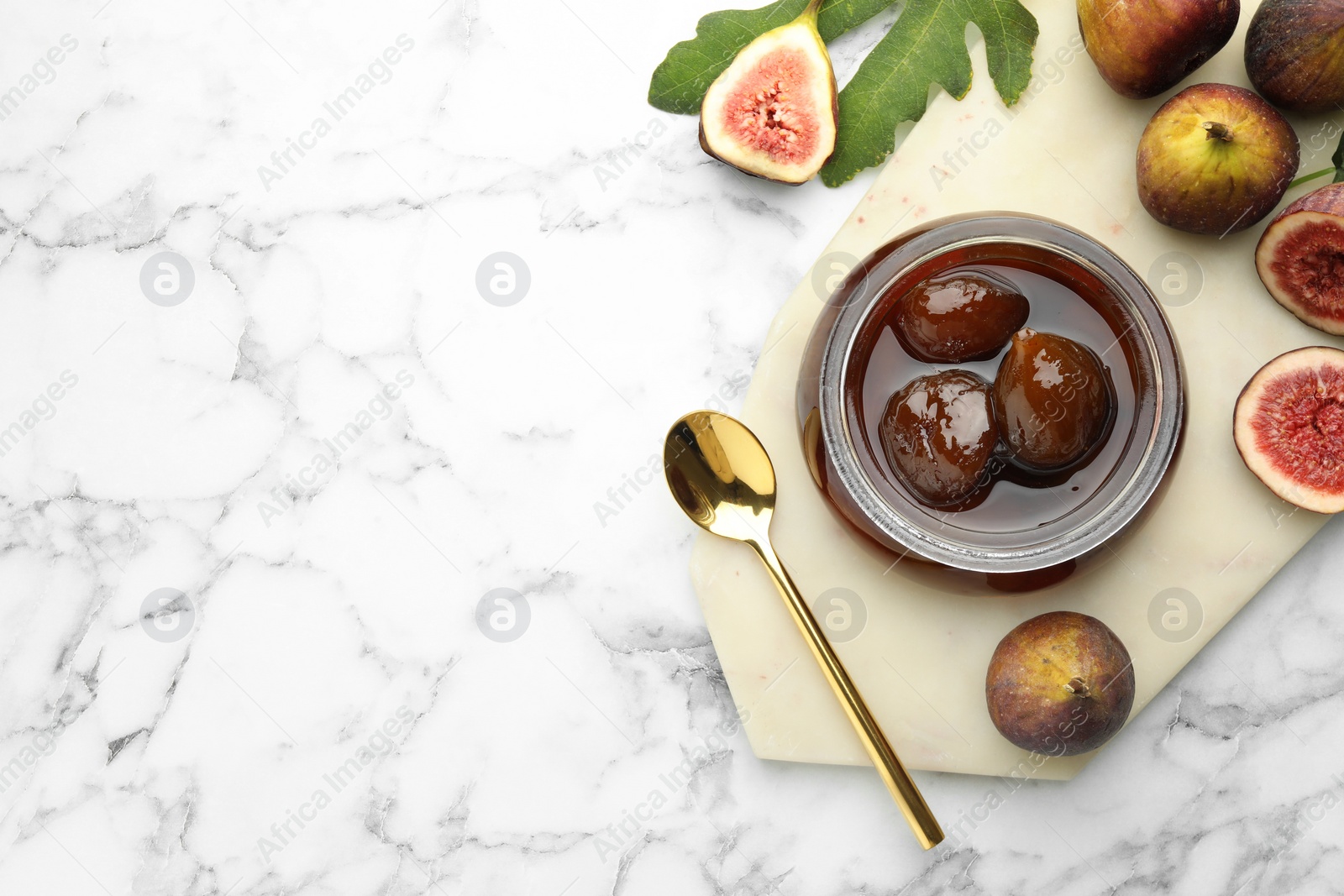 Photo of Jar of tasty sweet jam and fresh figs on white marble table, flat lay. Space for text