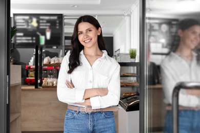 Photo of Happy business owner at door of her cafe