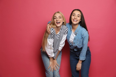 Photo of Young women laughing together against color background