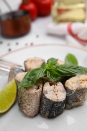 Photo of Canned mackerel chunks served on white table, closeup