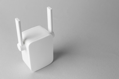 New modern Wi-Fi repeater on light gray background, space for text