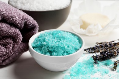 Photo of Beautiful turquoise sea salt, towel and dry flowers on white table