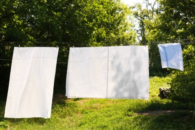 Washing line with clean laundry and clothespins outdoors