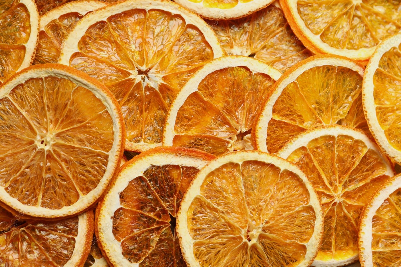 Photo of Heap of dry orange slices as background, top view