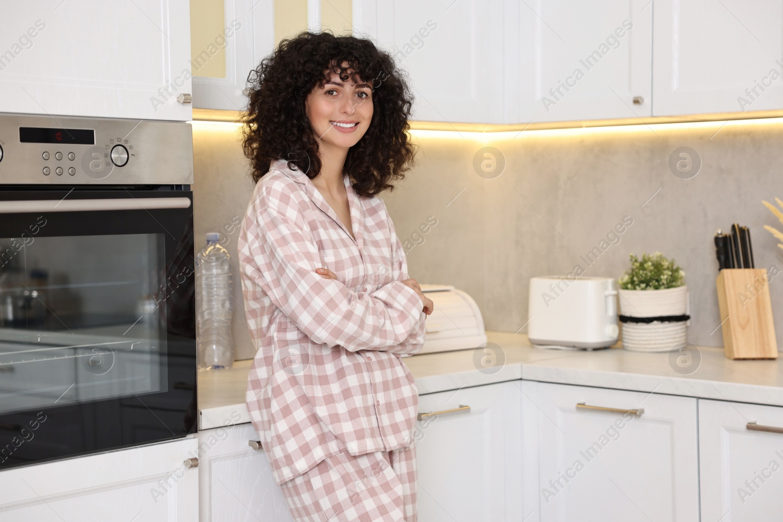 Photo of Beautiful young woman in stylish pyjama in kitchen