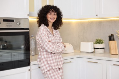 Photo of Beautiful young woman in stylish pyjama in kitchen