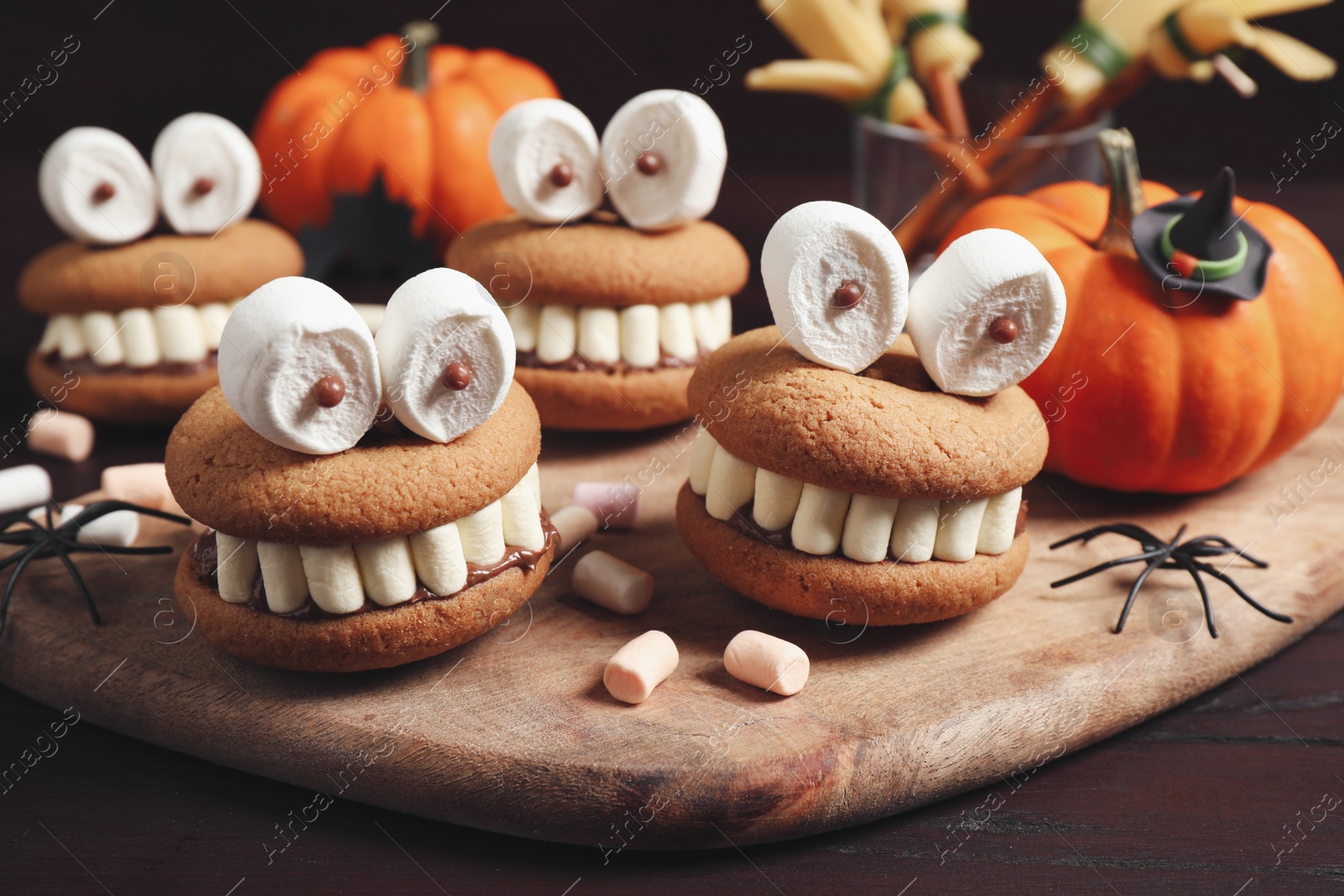 Photo of Delicious Halloween themed desserts on wooden table, closeup