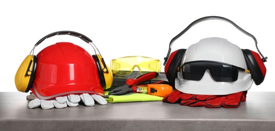 Set with safety equipment and tools on grey stone table against white background