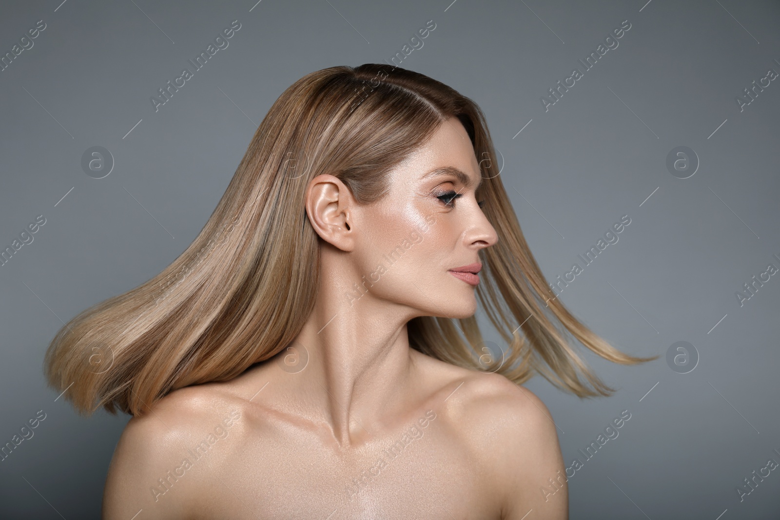 Image of Portrait of attractive woman with blonde hair on grey background