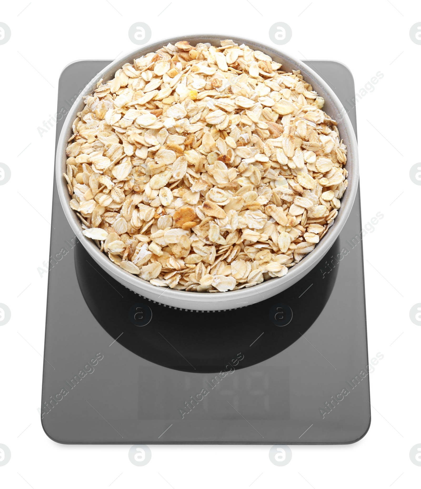 Photo of Modern kitchen scale with bowl of raw oatmeal isolated on white