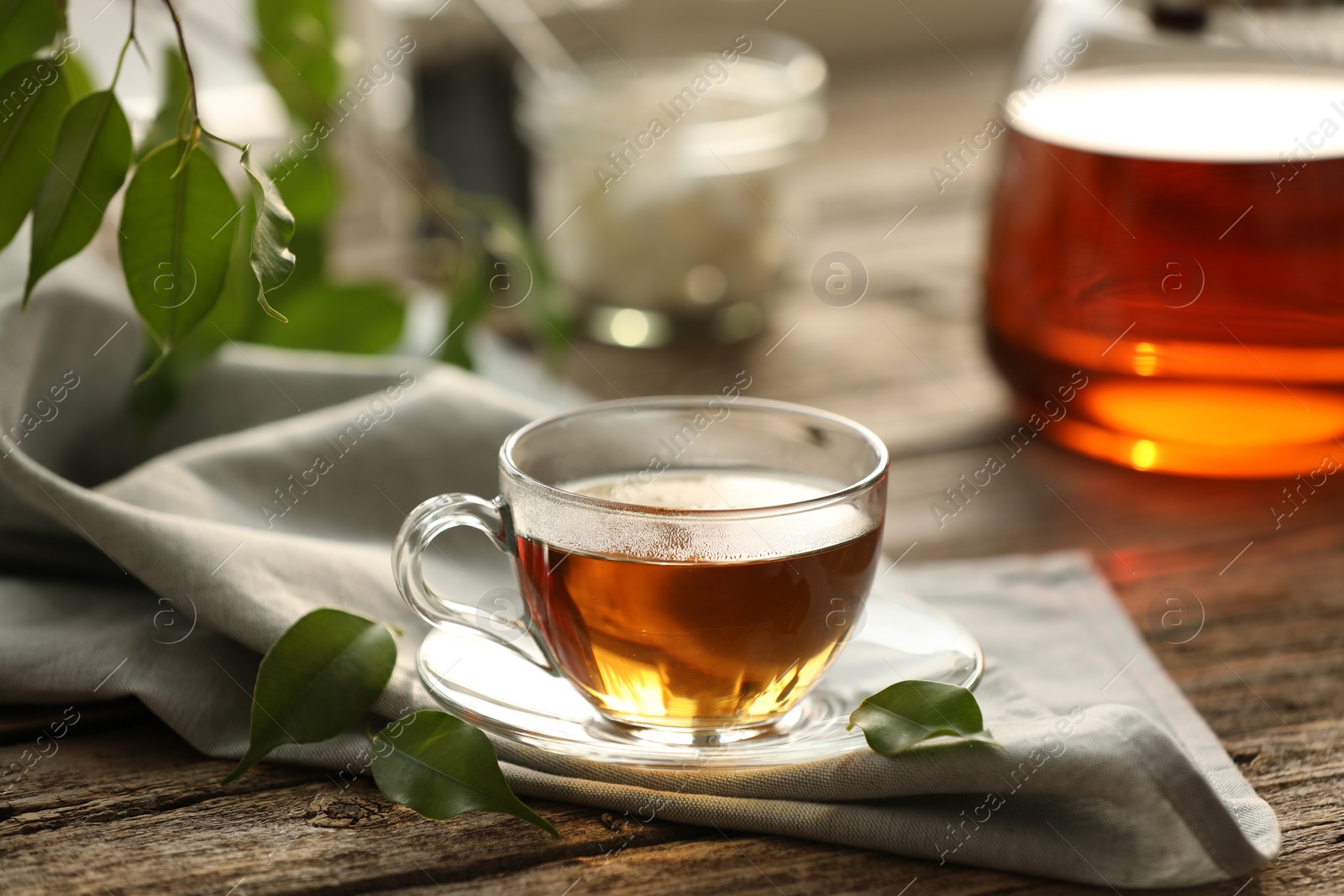 Photo of Tasty tea in cup on wooden table, closeup