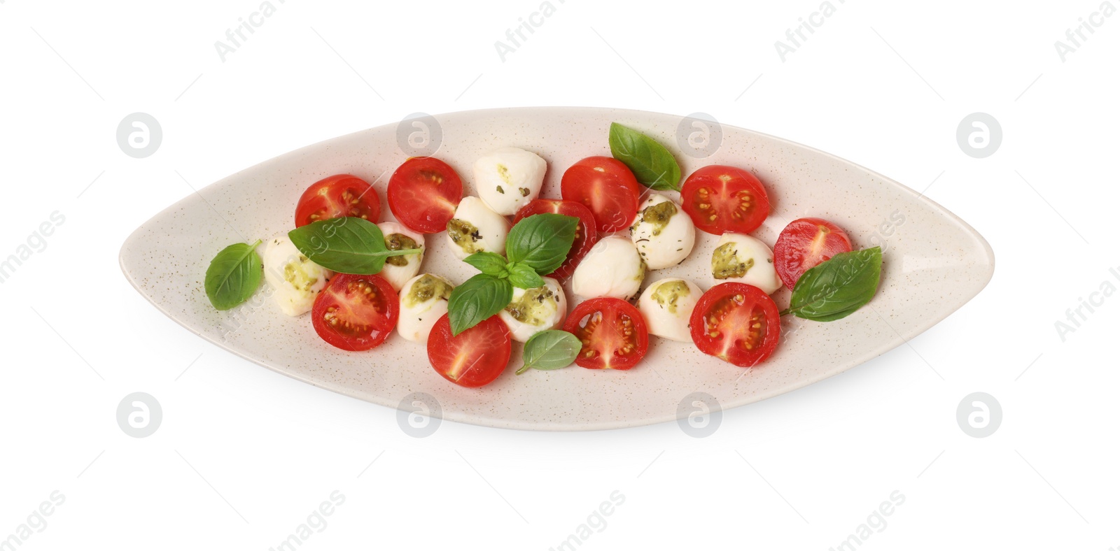 Photo of Plate of tasty Caprese salad with mozzarella, tomatoes, basil and pesto sauce isolated on white, top view