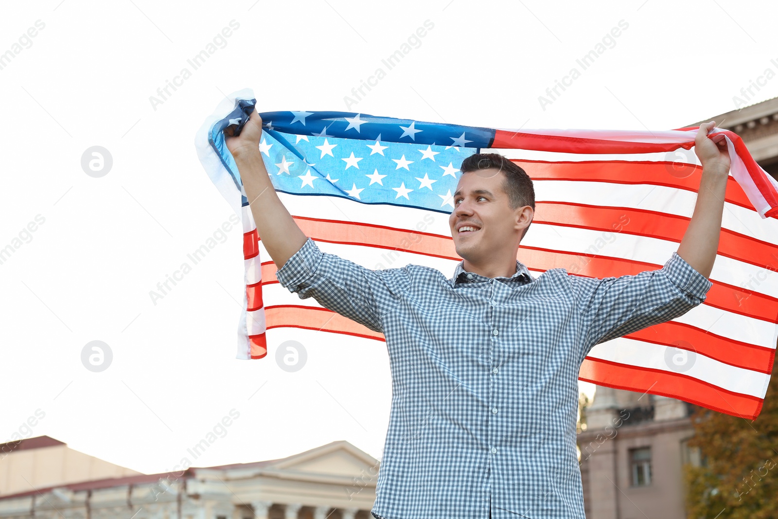 Photo of Man with American flag on city street