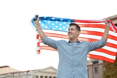 Man with American flag on city street