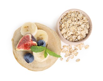 Photo of Tasty oatmeal pancakes and ingredients on white background, top view