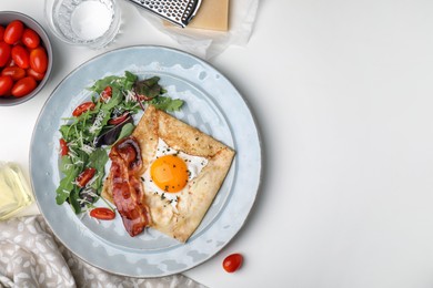 Delicious crepe with egg served on white table, flat lay with space for text. Breton galette