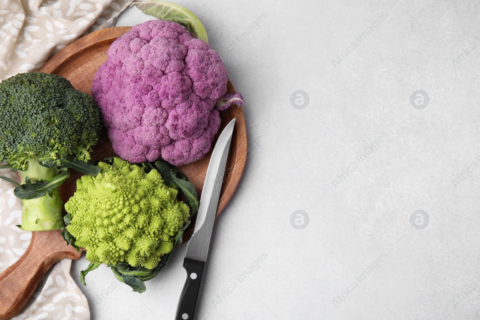 Photo of Different fresh cabbages on white table, flat lay. Space for text