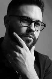 Portrait of handsome bearded man on grey background. Black and white effect