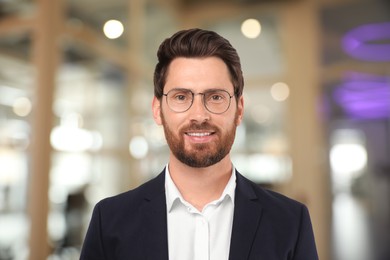 Image of Handsome confident man with eyeglasses in office