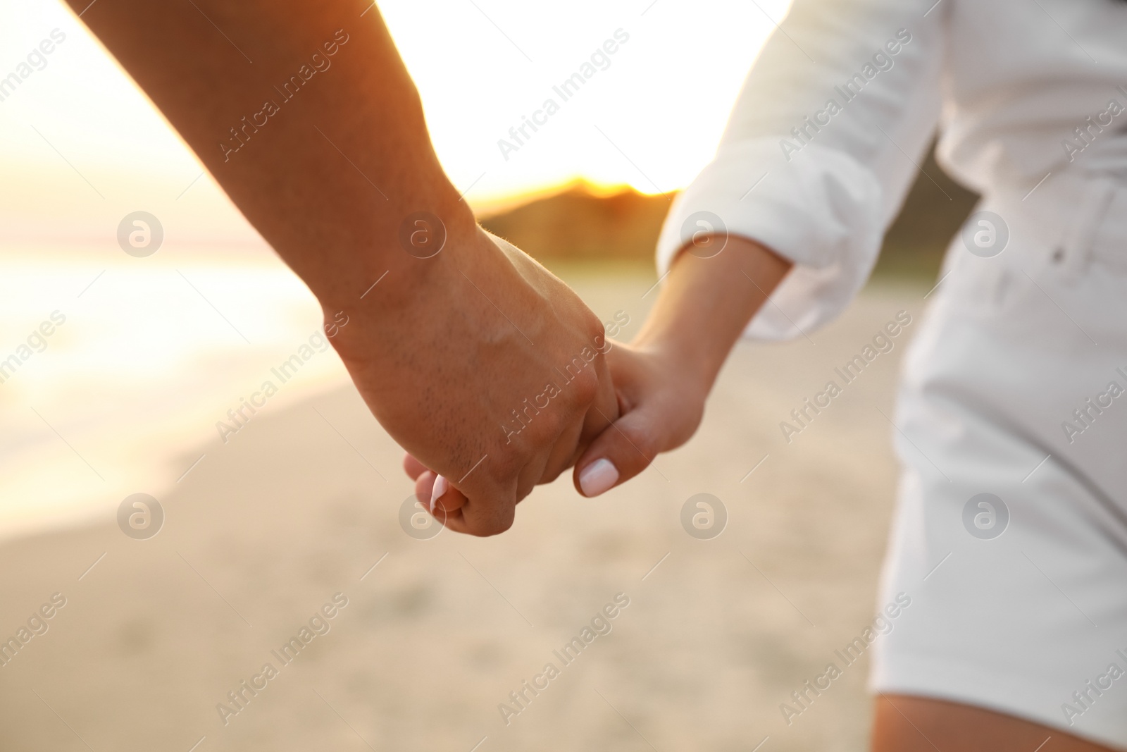 Photo of Lovely couple holding hands on beach, closeup