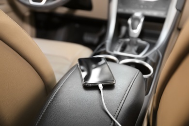 Photo of Mobile phone with charging cable in car