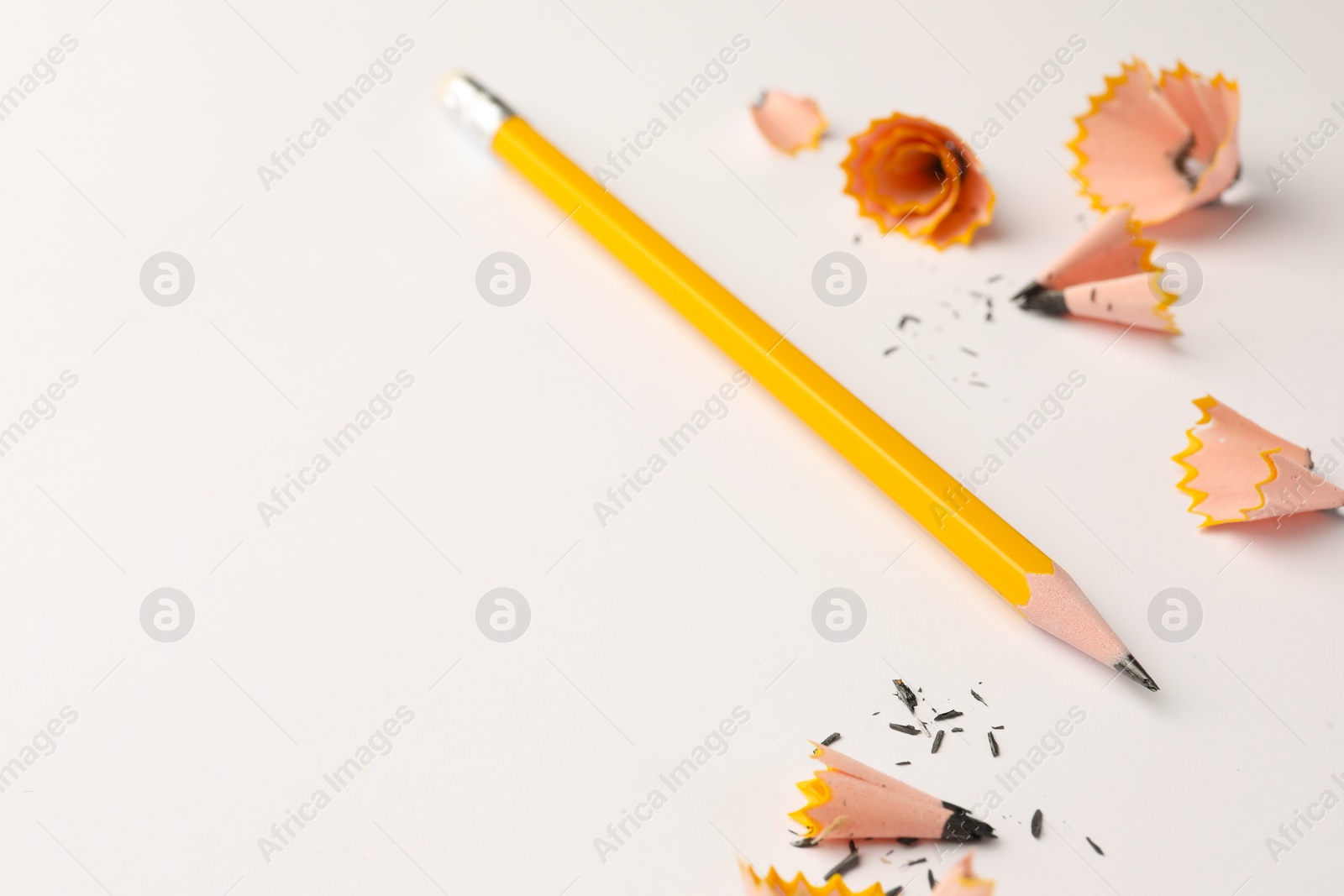 Photo of Graphite pencil and shavings on white background. Space for text