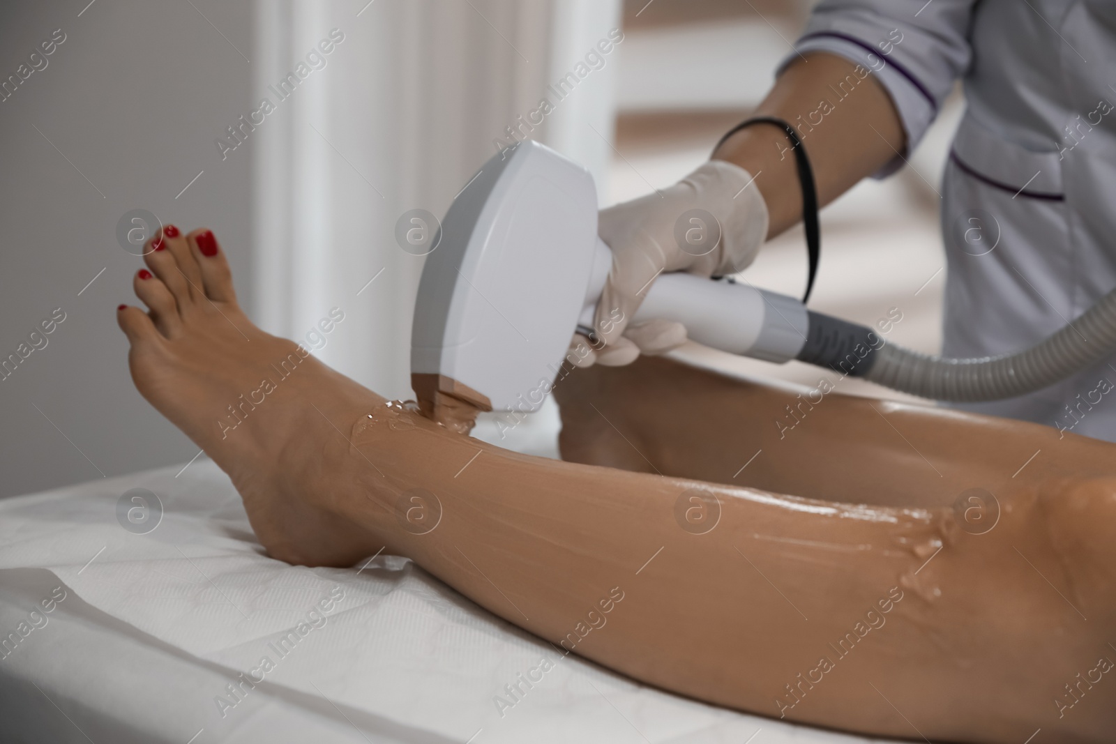 Photo of Woman undergoing laser epilation procedure in beauty salon, closeup