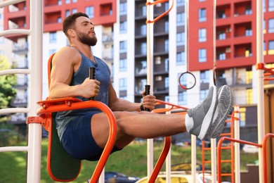 Photo of Man training on abs station at outdoor gym