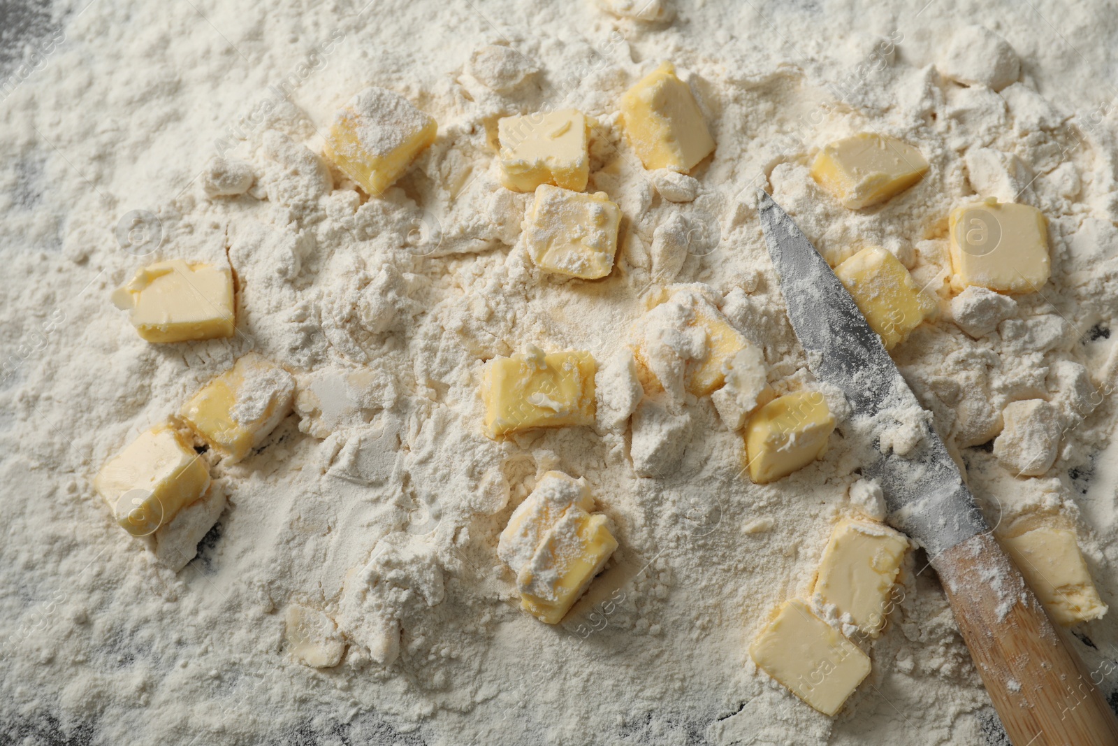 Photo of Making shortcrust pastry. Flour, butter and knife on table, top view