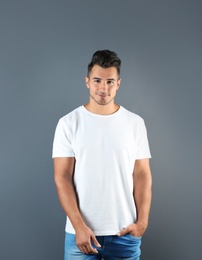 Photo of Young man in t-shirt on grey background. Mockup for design