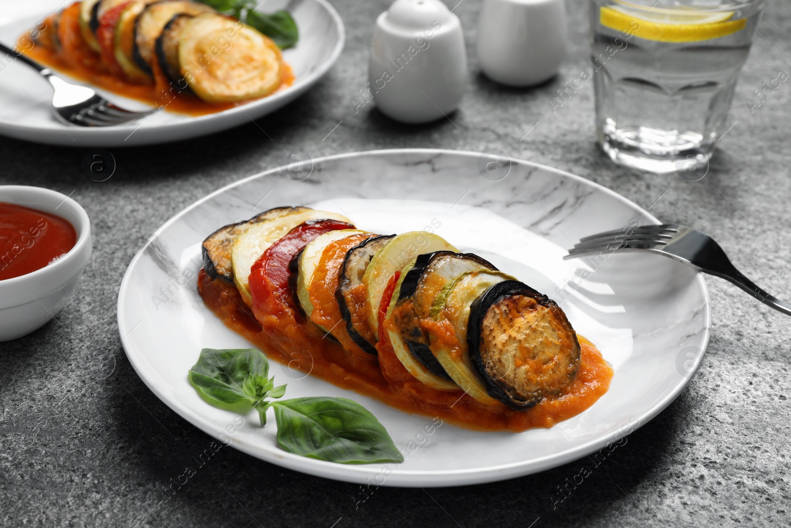 Photo of Delicious ratatouille served on grey table, closeup