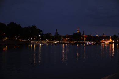 Beautiful view of illuminated city near river at night