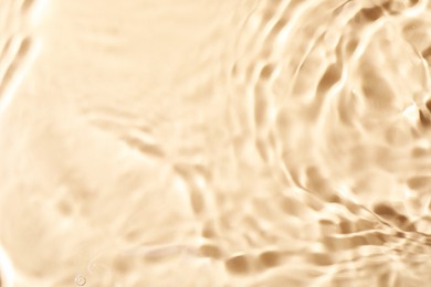 Closeup view of water with rippled surface on beige background