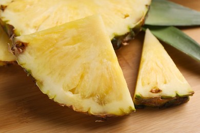 Photo of Slices of ripe juicy pineapple on wooden board, closeup