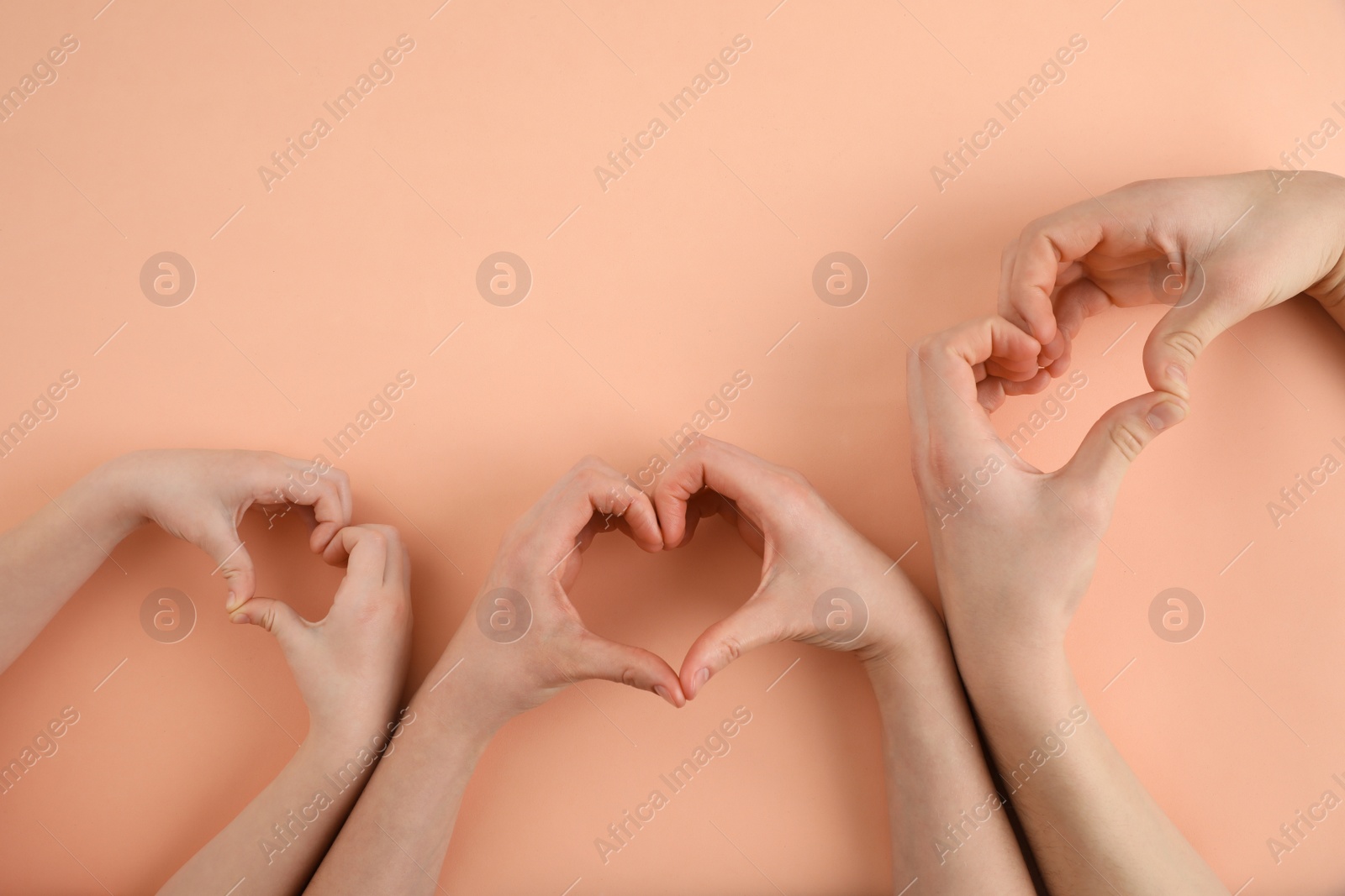 Photo of Happy family holding hands on beige background, top view. Space for text