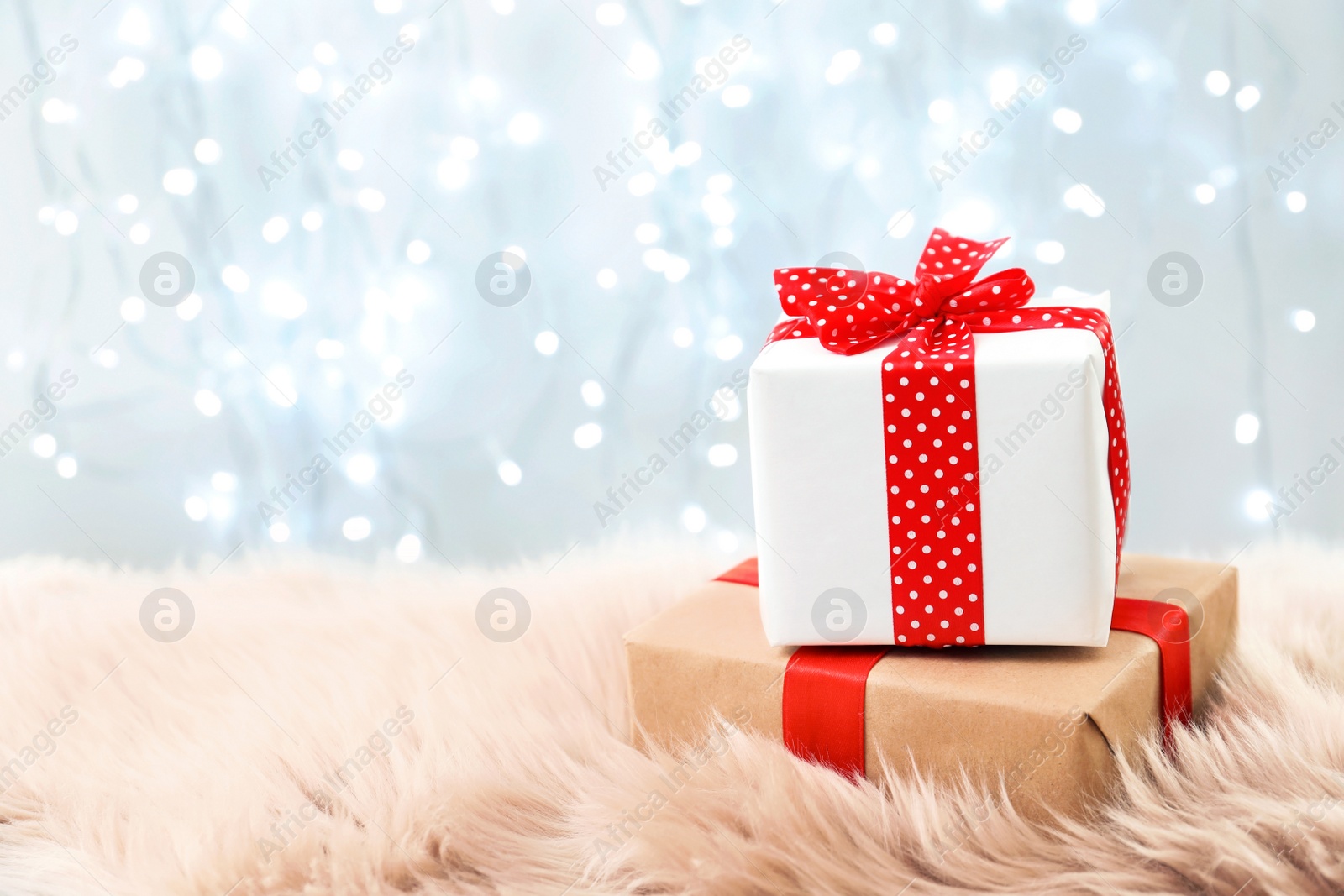 Photo of Christmas gifts on fur against blurred background