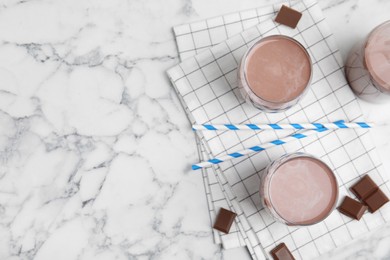 Photo of Delicious chocolate milk on white marble table, flat lay. Space for text