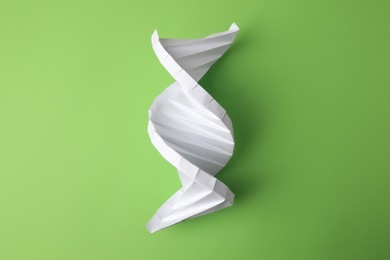 Photo of Paper model of DNA molecular chain on green background, top view