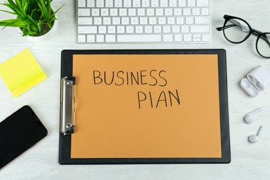 Business plan. Flat lay composition with clipboard and computer keyboard on white table