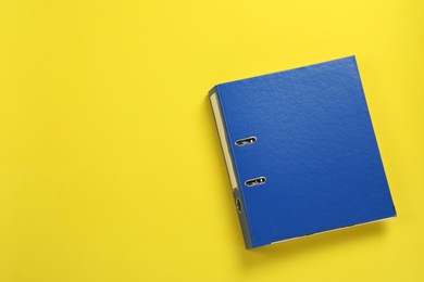 Photo of Blue office folder on yellow background, top view, Space for text
