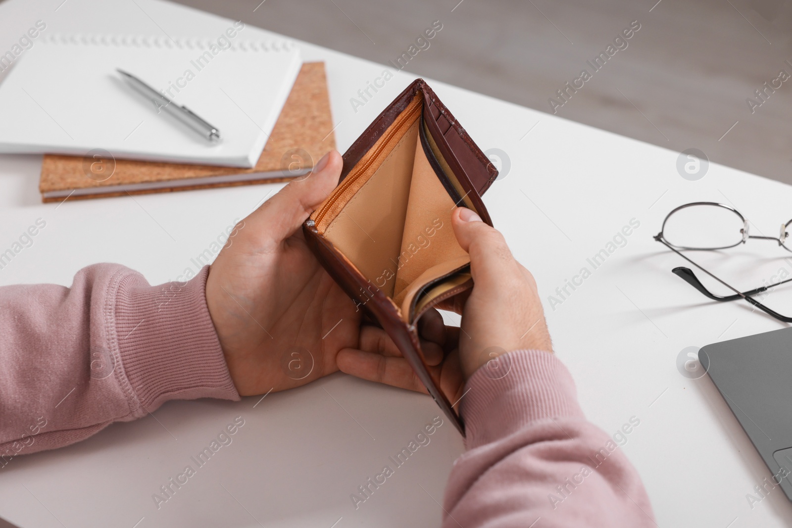 Photo of Man with empty wallet at white table indoors, closeup