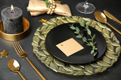 Elegant festive table setting with blank card on black background