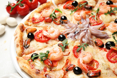 Photo of Tasty fresh pizza with seafood on table, closeup