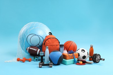 Photo of Many different sports equipment on light blue background